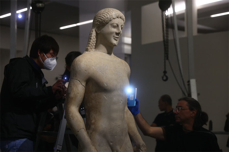 Μ?λη του Εθνικο? Αρχαιολογικο? Μουσε?ου στην Αθ?να εξετ?ζουν ?να ανδρικ? ?γαλμα που θα εκτεθε? στην ?κθεση Αμ?τρητε? ?ψει? τη? Ομορφι?? στην Αρχα?α Τ?χνη. Φωτογραφ?α: China Daily