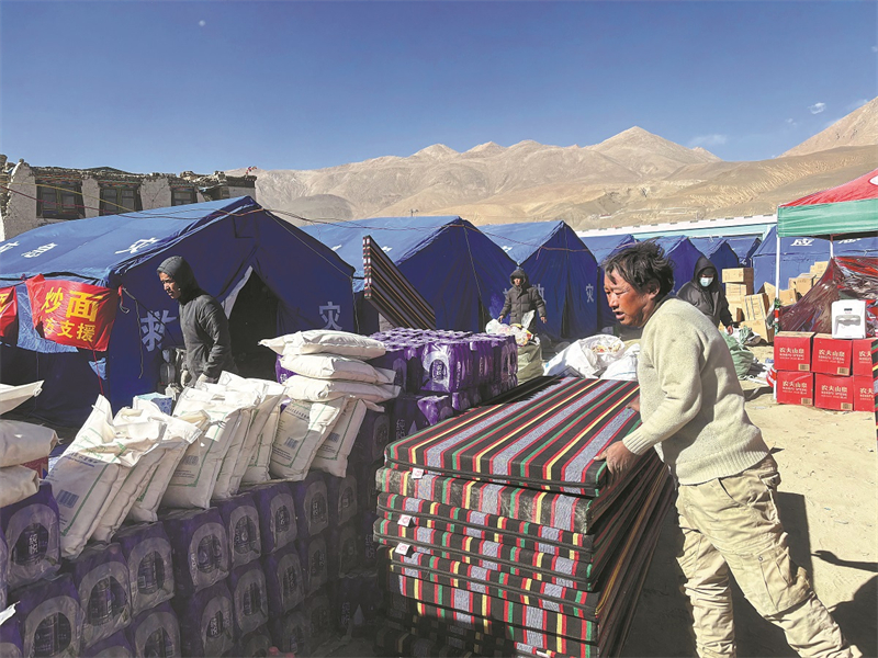 Οι κ?τοικοι του χωριο? μεταφ?ρουν υλικ? ?πω? στρ?ματα και τρ?φιμα που ?λαβαν απ? την κυβ?ρνηση στο Τρακτσο?νγκ, ?να χωρι? στην περιοχ? Δρ?μσο του δ?μου Ντ?γκρι, την Π?μπτη 89/1/2025. Φωτογραφ?α: China Daily