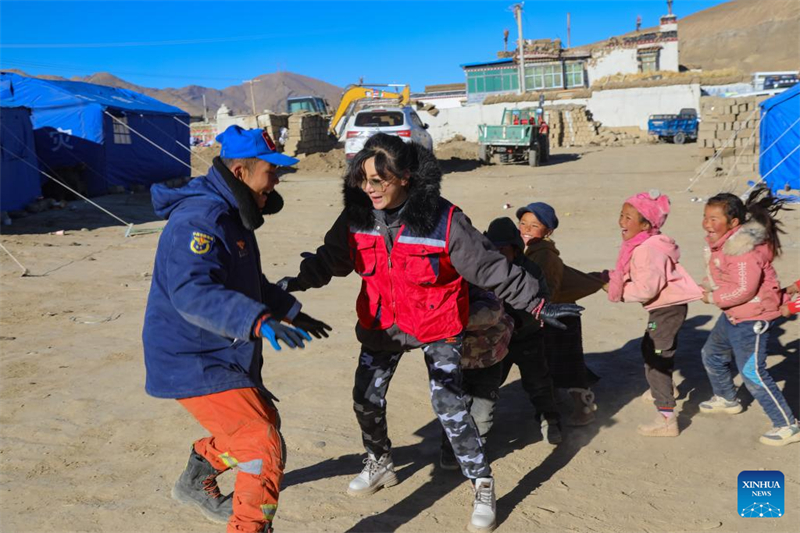 Η Ταν Σιρ?ν (2η απ? αριστερ?) και ?να? διασ?στη? (1ο? απ? αριστερ?) πα?ζουν παιχν?δια με παιδι? σε προσωριν? καταυλισμ? των σεισμ?πληκτων στο χωρι? Τσου?νγκ τη? κοιν?τητα? Κουλ?ου στην κομητε?α Ντινγκρ?, στην π?λη Σιγκ?τζε, στην αυτ?νομη περιοχ? Σιζ?νγκ τη? νοτιοδυτικ?? Κ?να?, στι? 10 Ιανουαρ?ου 2025. (Φωτογραφ?α / Xinhua)