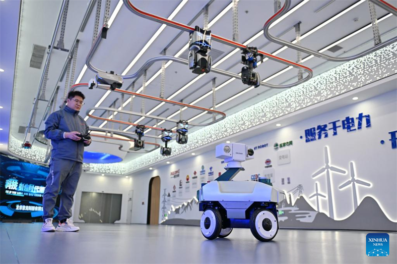 ?να μ?λο? του προσωπικο? ρυθμ?ζει ?να περιπολικ? ρομπ?τ σε μια πιλοτικ? β?ση δοκιμ?ν στη Ν?α Περιοχ? Σι?νγκ’αν, στην επαρχ?α Χεμπ?ι τη? β?ρεια? Κ?να?, στι? 26 Μαρτ?ου 2025. (Φωτογραφ?α / Xinhua)