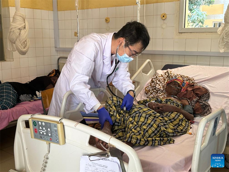 Μ?λο? τη? 22η? αποστολ?? τη? κινεζικ?? ιατρικ?? ομ?δα? στη Γκ?μπια εξετ?ζει ασθεν? στο Γενικ? Νοσοκομε?ο Φαραφ?νι στην περιοχ? Β?ρεια ?χθη, Γκ?μπια, 8 Απριλ?ου 2025. (Φωτογραφ?α / Xinhua)