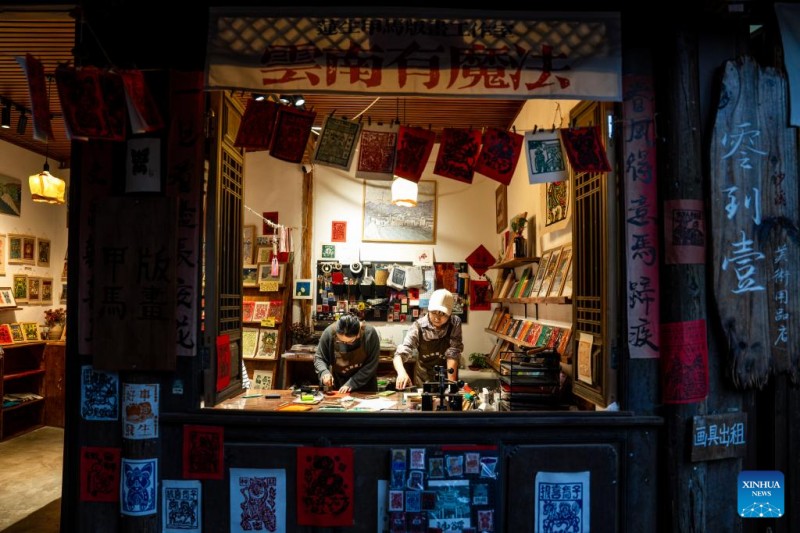 ?να? τουρ?στα? (αριστερ?) δοκιμ?ζει να δημιουργ?σει ?να τοπικ? παραδοσιακ? ξυλ?τυπο γνωστ? ω? Jiama στο χωρι? Σιντ?νγκ τη? π?λη? Σ?σι, στην κομητε?α Τζιεντσου?ν, στη νοτιοδυτικ? Κ?να, στην επαρχ?α Γιουν?ν, 18 Απριλ?ου 2025. 