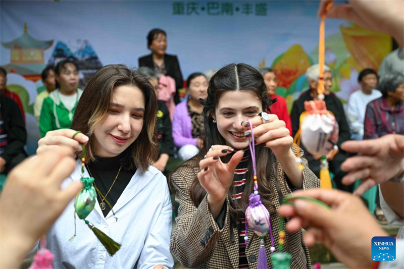 Οι κ?τοικοι τη? περιοχ?? και οι διεθνε?? φοιτητ?? προσπαθο?ν να φτι?ξουν φακελ?κια στην αρχα?α π?λη Φενγκσ?νγκ τη? περιοχ?? Μπαν?ν στον Δ?μο Τσονγκκ?νγκ, στι? 28 Μα?ου του 2025. (Φωτογραφ?α / Xinhua)