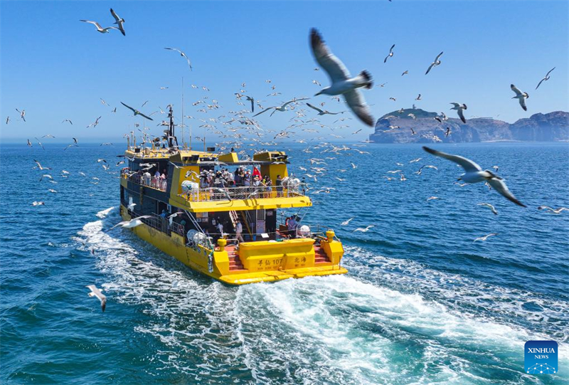 Φωτογραφ?α απ? drone που τραβ?χτηκε στι? 23 Ιουν?ου του 2025 δε?χνει τουρ?στε? να απολαμβ?νουν μια περι?γηση με σκ?φο? στην π?λη Ρονγκτσ?νγκ τη? επαρχ?α? Σαντ?νγκ. (Φωτογραφ?α / Xinhua)