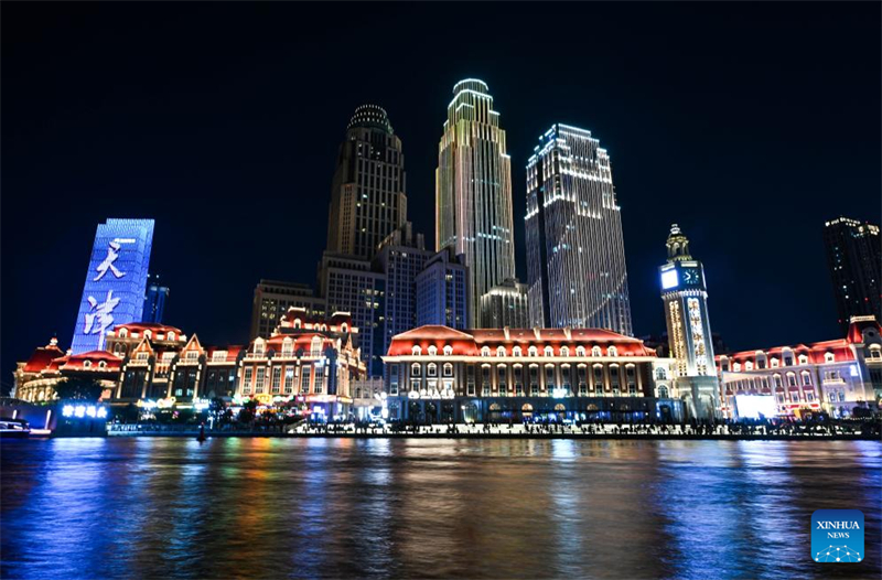 Πολ?τε? και τουρ?στε? απολαμβ?νουν τη νυχτεριν? θ?α στον ποταμ? Χα?χ? στον Δημο Τιεντζ?ν, στι? 11 Αυγο?στου του 2025. (Φωτογραφ?α / Xinhua)