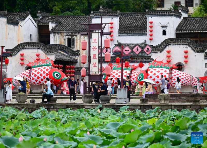 Τουρ?στε? παρακολουθο?ν τα φαν?ρια σε σχ?μα ψαριο? στο χωρι? Τσενγκκ?ν, τη? επαρχ?α? Ανχου?ι, στι? 21 Αυγο?στου του 2025. 