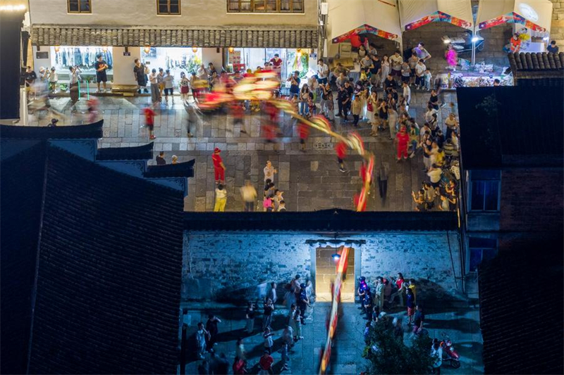 Αεροφωτογραφ?α που τραβ?χτηκε στι? 5 Οκτωβρ?ου του 2025 δε?χνει ανθρ?που? να παρακολουθο?ν μια παρ?σταση του χορο? του δρ?κου απ? ξ?λινο π?γκο στην κομητε?α Πουτζι?νγκ τη? επαρχ?α? Τζετζι?νγκ. (Φωτογραφ?α / Xinhua)